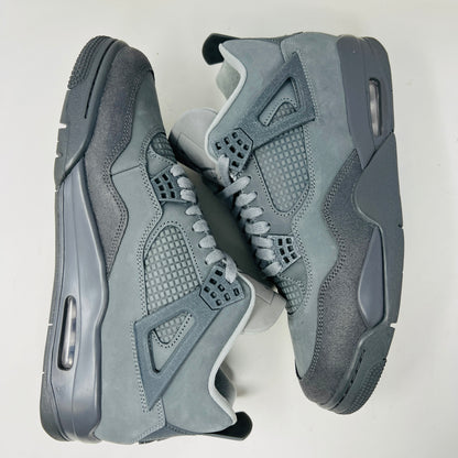 The Jordan 4 Retro SE Paris Olympics Wet Cement sneaker is displayed on its matching gray textured box, showcasing both in pristine condition. It features clean uppers with smooth and mesh textures, a visible air unit, and a size label with US, UK, and EU measurements.