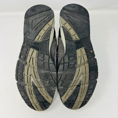 A New Balance 991 Slam Jam sneaker, in black and gray, sits on its box with tags attached. Red and black extra laces are neatly displayed in front, ready to refresh its look.