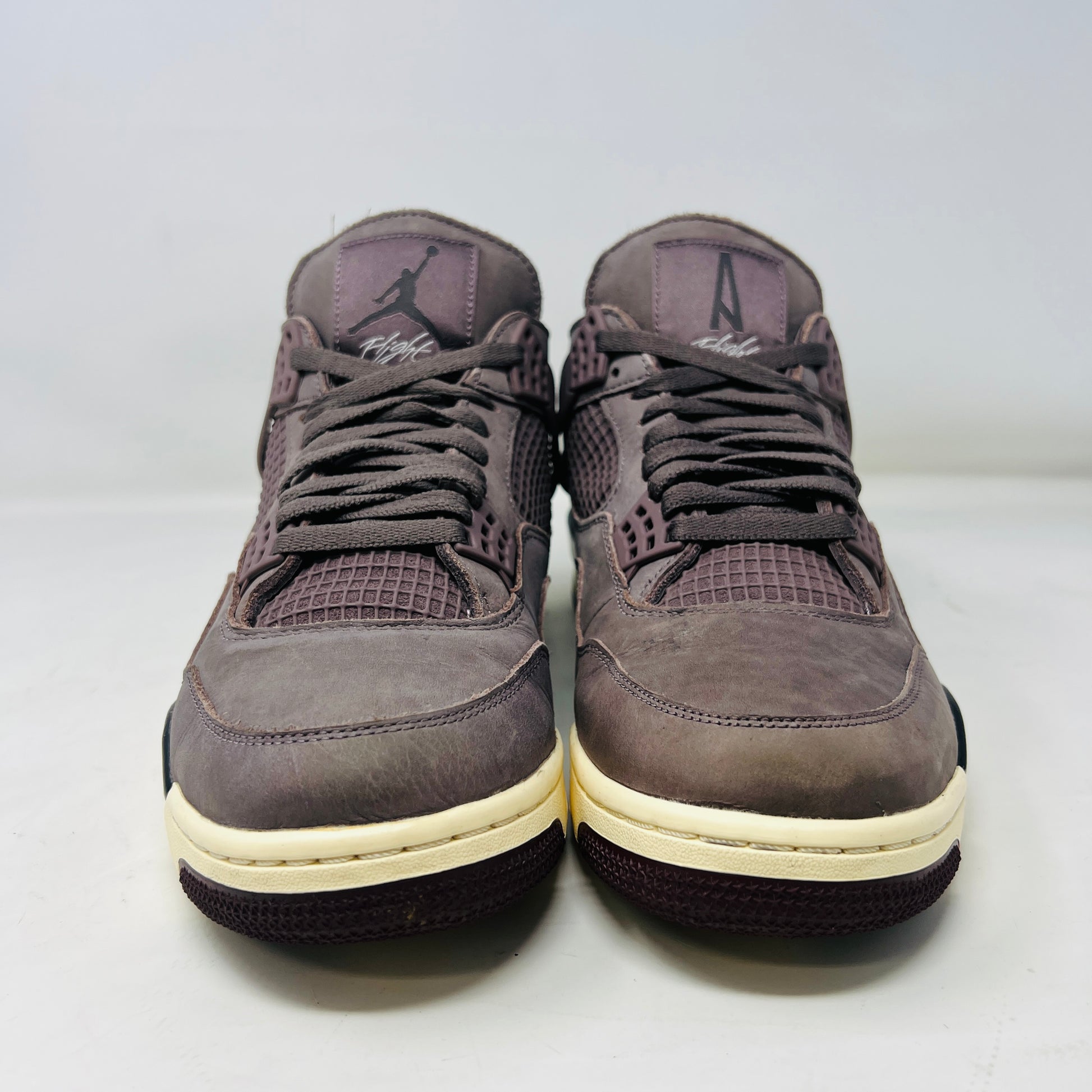 The Jordan 4 Retro SP A Ma Maniére Violet Ore sneakers sit elegantly on their matching box, featuring unique netting and black accents. The box displays size and brand details, emphasizing its immaculate condition.