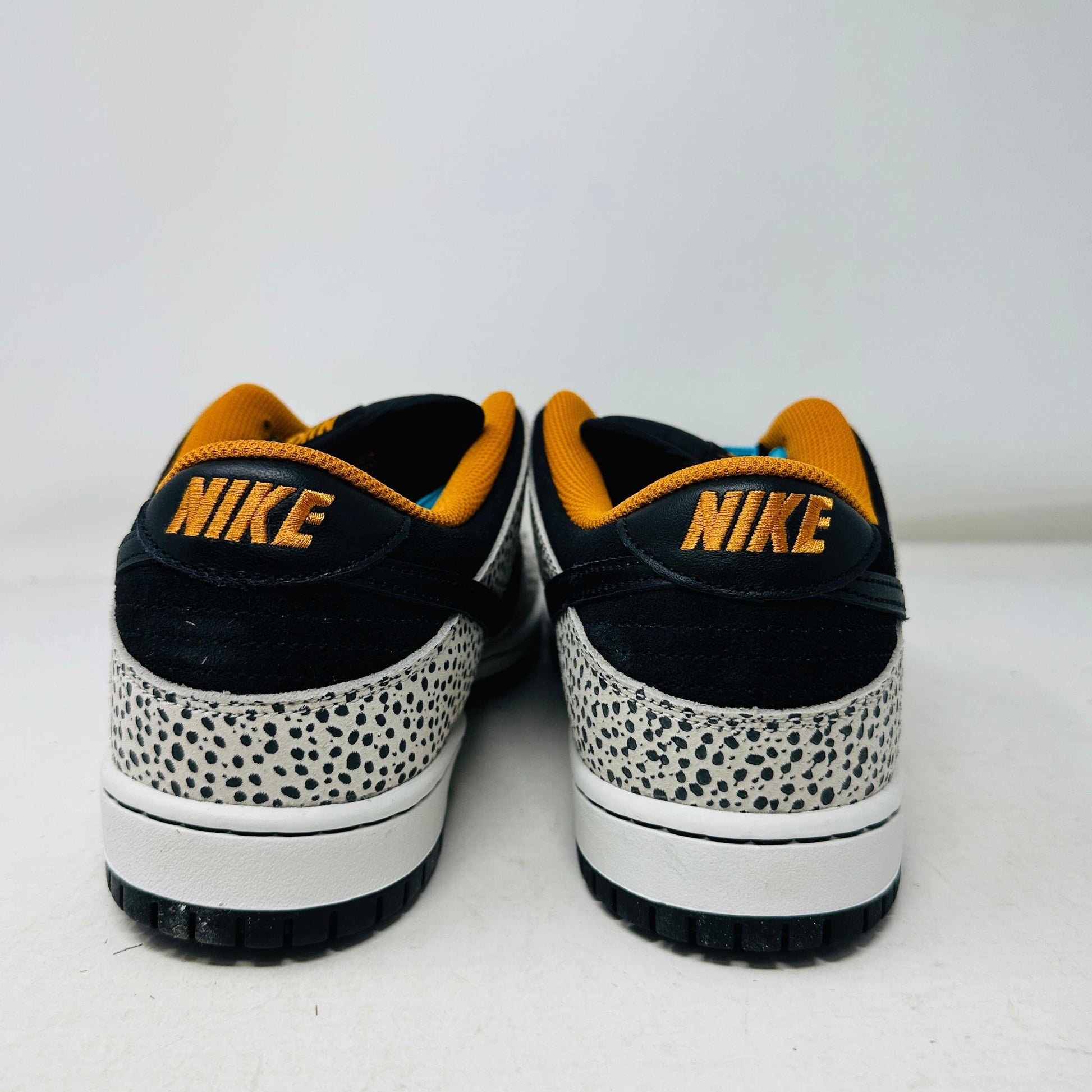 The Nike SB Dunk Low Electric Pack Olympic Safari, a new 2024 release, showcases a speckled gray and white design with a black swoosh, blue laces, and orange lining, elegantly set upon its box against a plain backdrop.