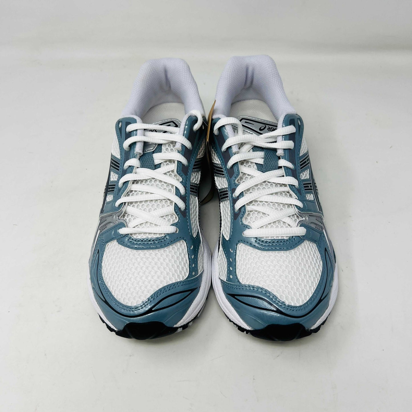 The ASICS Gel-Kayano 14 White Fjord Grey running shoe stands on a brown ASICS box, featuring intricate designs, a breathable mesh upper, and a cushioned thick sole for support. Its 100% authentic.