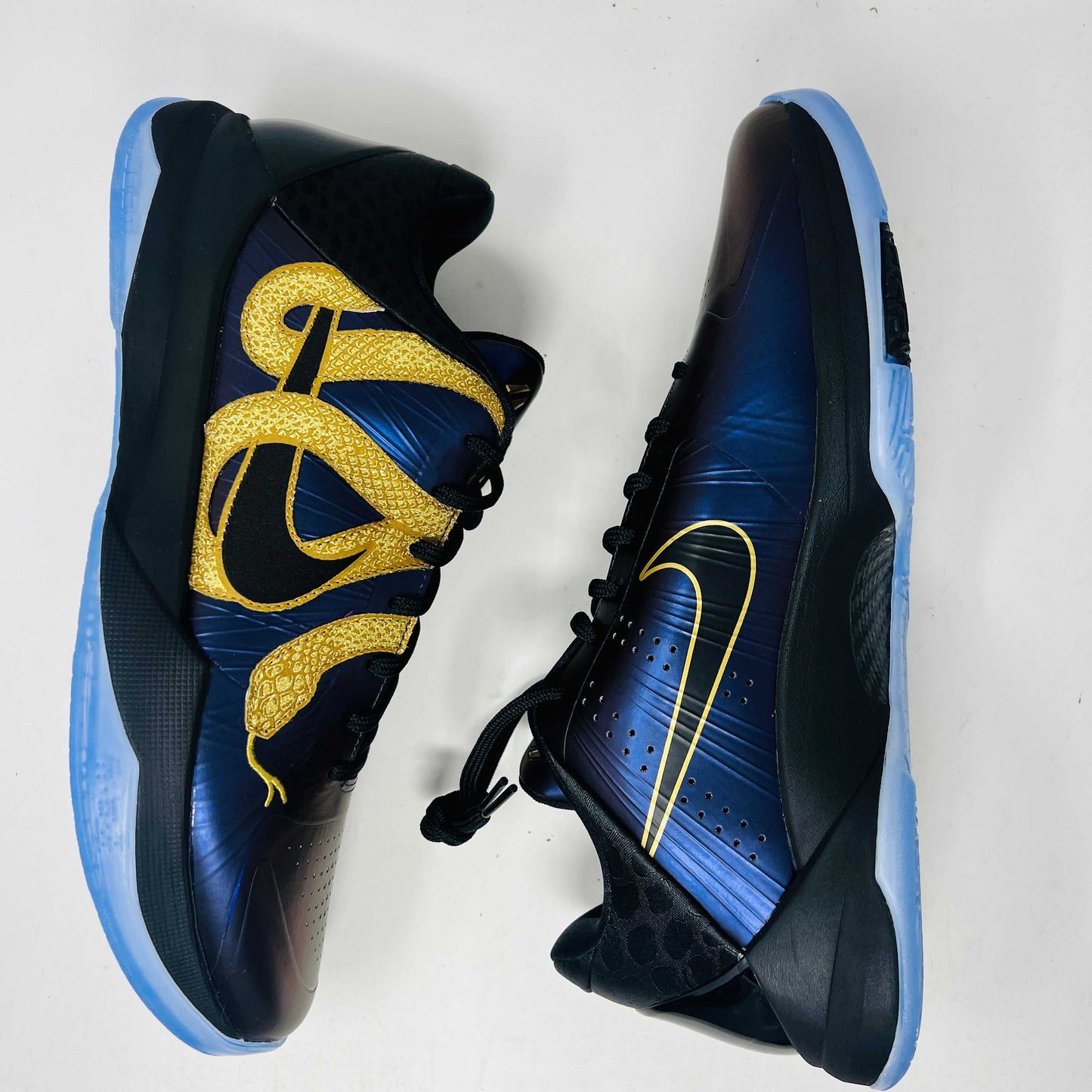 The Nike Kobe 5 Protro Year of the Mamba Eggplant sneakers offer a stylish design with purple and gold colors, black laces, and an authentic tongue logo. They feature perforated side panels, a shiny finish, and include a dust bag for easy storage.