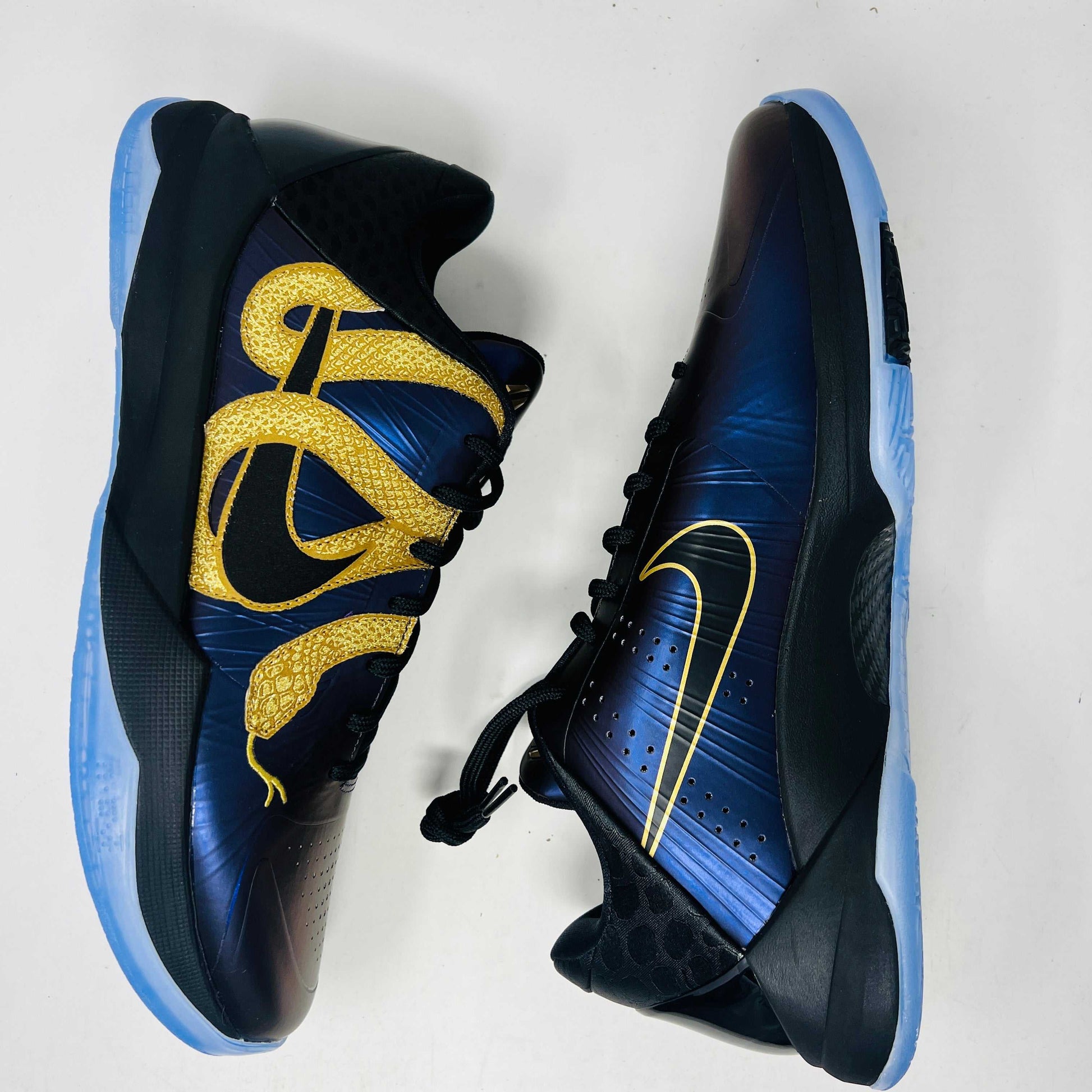 The Nike Kobe 5 Protro Year of the Mamba Eggplant sneakers offer a stylish design with purple and gold colors, black laces, and an authentic tongue logo. They feature perforated side panels, a shiny finish, and include a dust bag for easy storage.