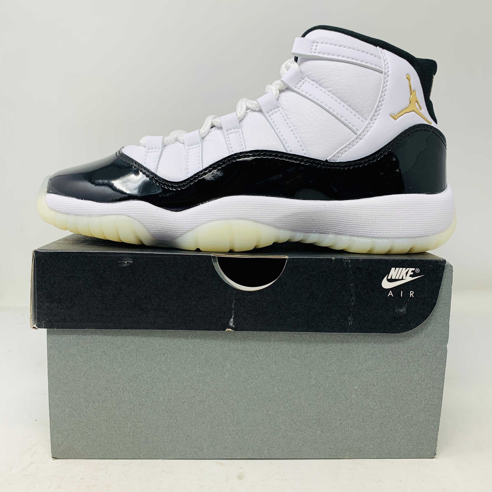 Jordan 11 Retro DMP Gratitude 2023 GS sneakers in black and white on shoe box.
