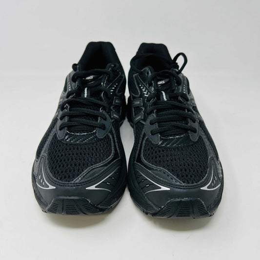 The new ASICS GT-2160 JJJJound Black running shoe sits on its box, featuring extra laces in a clear bag. These authentic shoes present a sleek design with gray detailing and a side text label.