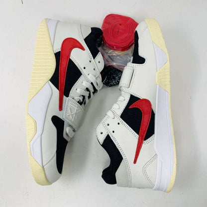 Authentic Jordan Jumpman Jack TR Travis Scott University Red shoes with white and black uppers feature red swoosh logos, resting sideways on a white surface. The soles have a slightly yellowed hue. Brand new red shoelaces are packaged in plastic, placed between the shoes, ready to complete this 2024 style statement.
