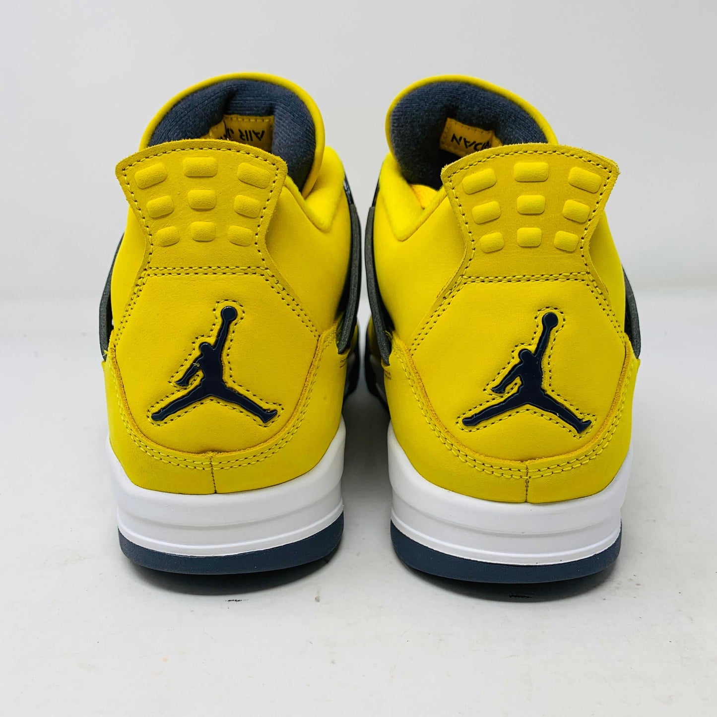 Jordan 4 Lightning sneakers in yellow and black, featuring bold lightning bolt accents.