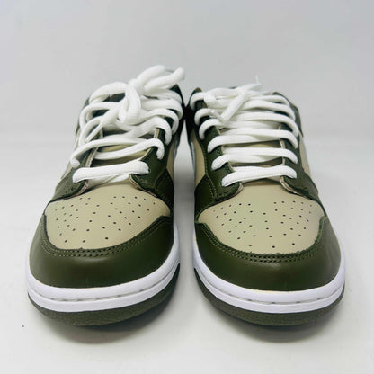 A Nike Dunk Low Light Stone shoe in green and beige with brand new white laces is displayed atop an orange Nike box. Extra white laces are in front, ensuring this 100% authentic pair from the Nike Dunk collection is ready to step out in style.