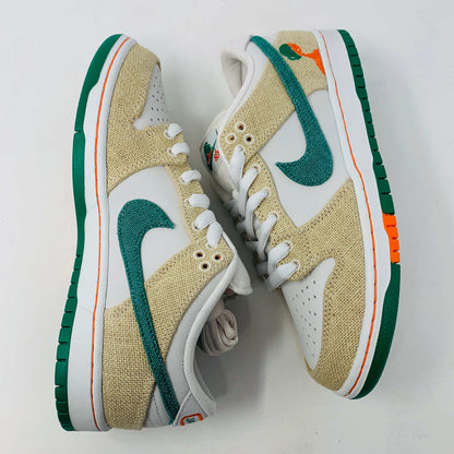 Front view of a brand new pair of Nike SB Dunk Low Jarritos sneakers in beige and white with green accents, featuring textured beige material, perforated toe panels, white laces, and swoosh logos on the tongues. Extra 2 laces included; displayed on a plain white background.
