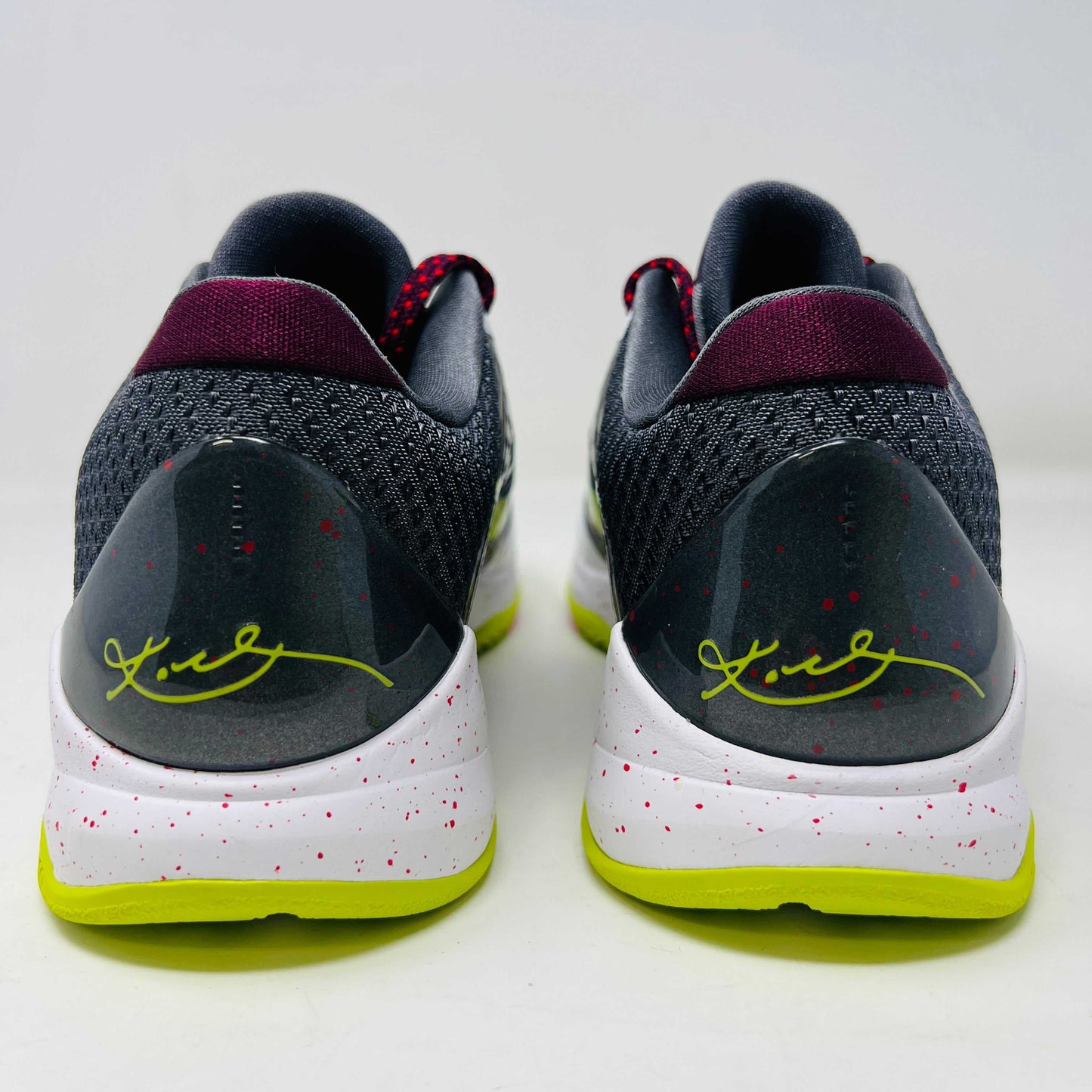 The Nike Kobe 5 Protro Chaos sneaker, authentic and vibrant, is showcased on a black shoe box. It features a bright lime green Nike swoosh, purple and white accents, a speckled pink midsole, red-speckled laces, and a textured gray heel.