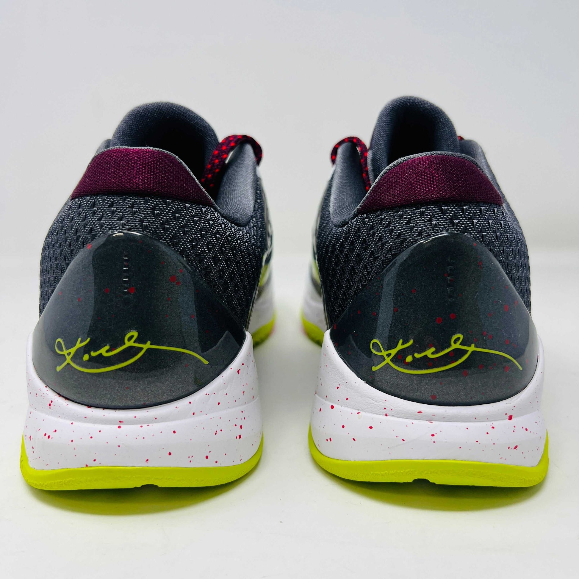 The Nike Kobe 5 Protro Chaos sneaker, authentic and vibrant, is showcased on a black shoe box. It features a bright lime green Nike swoosh, purple and white accents, a speckled pink midsole, red-speckled laces, and a textured gray heel.