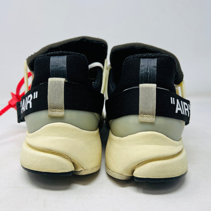 The 2017 classic Nike Air Presto Off-White features a black sneaker with white laces, a red tag, iconic AIR text, and an edgy zip tie. Displayed on its box, it includes extra black, neon green, and orange laces labeled SHOELACES.