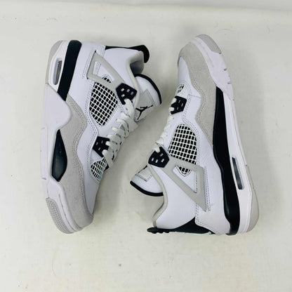 The Jordan 4 Military Black GS sneakers, featuring distinctive side netting and a logo on the tongue, are brand new and authentic in white and gray with black accents. They face forward on a white surface against a plain background, embodying modern style.