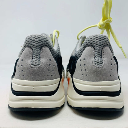A Yeezy 700 Waverunner with a multicolor scheme of gray, black, teal, and orange rests on a Yeezy Boost 700 Made by Adidas box. Sales are final on these authentic shoes.