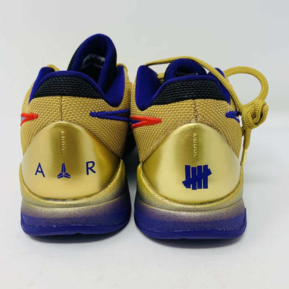 The Nike Kobe 5 Protro Undefeated Hall of Fame sneaker features a gold and purple design with a red swoosh, numbers 24 10 8 on the side, and comes with extra purple laces atop an orange box—100% authentic and perfect for any collection.