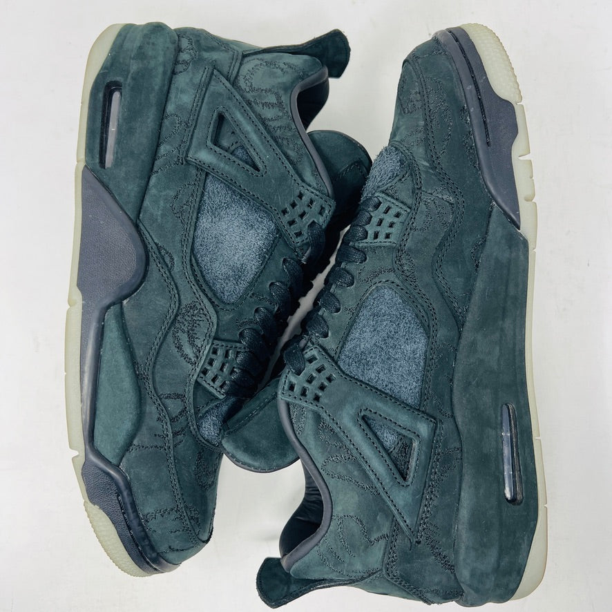 A dark green suede sneaker with a textured design, reminiscent of OG ALL styles, sits atop a matching box. Tagged size 10.5, it features a small red Jumpman logo and includes a XX AIR keychain from its 2017 release. Product: Jordan 4 Retro Kaws Black by Jordan.