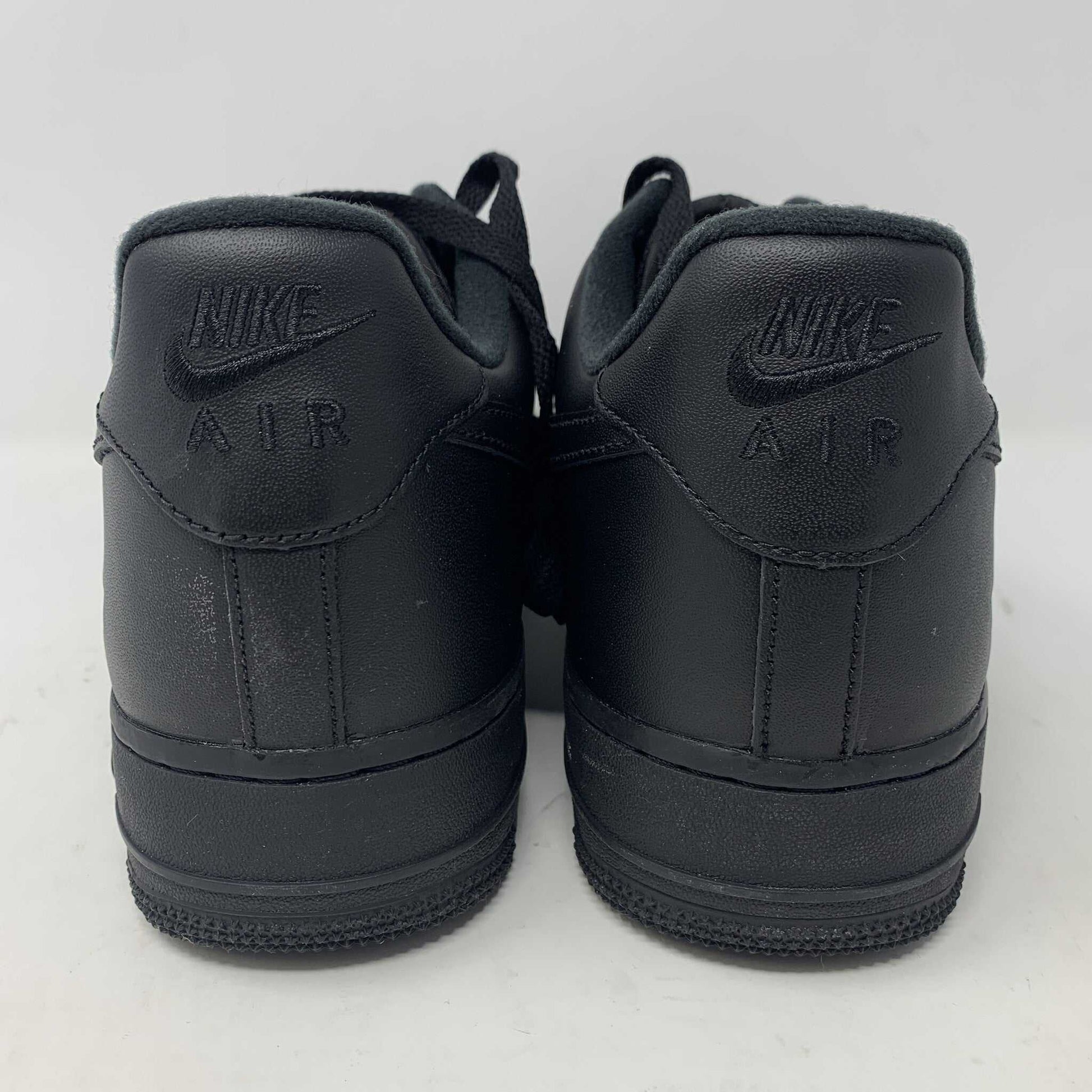 The Nike Supreme Air Force 1 Black features a perforated design on the toe box, black supreme laces with a shiny tag, and a prominent Nike logo, all set against a plain white background.