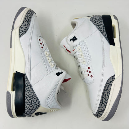 The Jordan 3 Retro White Cement Reimagined features white uppers with gray elephant print and red details, displayed on a black Nike Air shoebox. The size on the box reads 11, and the sneakers are pristine, free from heel drag.