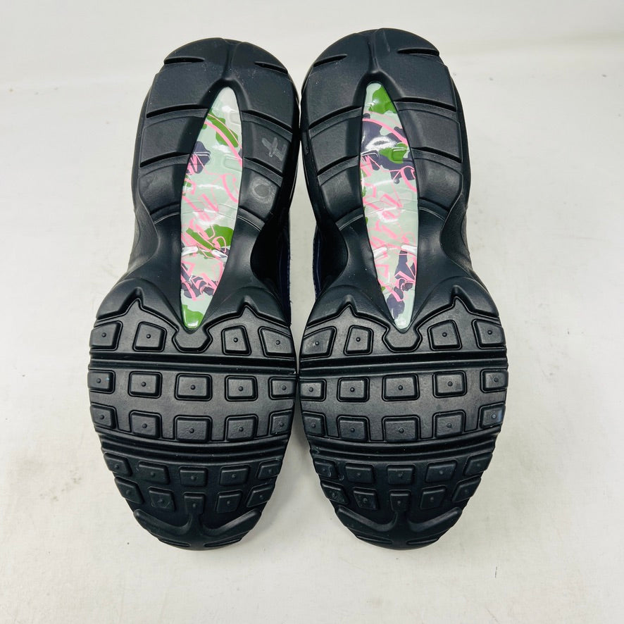 Introducing the Nike Air Max 95 SP Corteiz Pink Beam, black sneakers with textured design and purple accents. They feature a pink logo on the tongue, green and gray camo inner lining, black laces with toggle fasteners, fitting perfectly into 2021 fashion trends; available without a box.