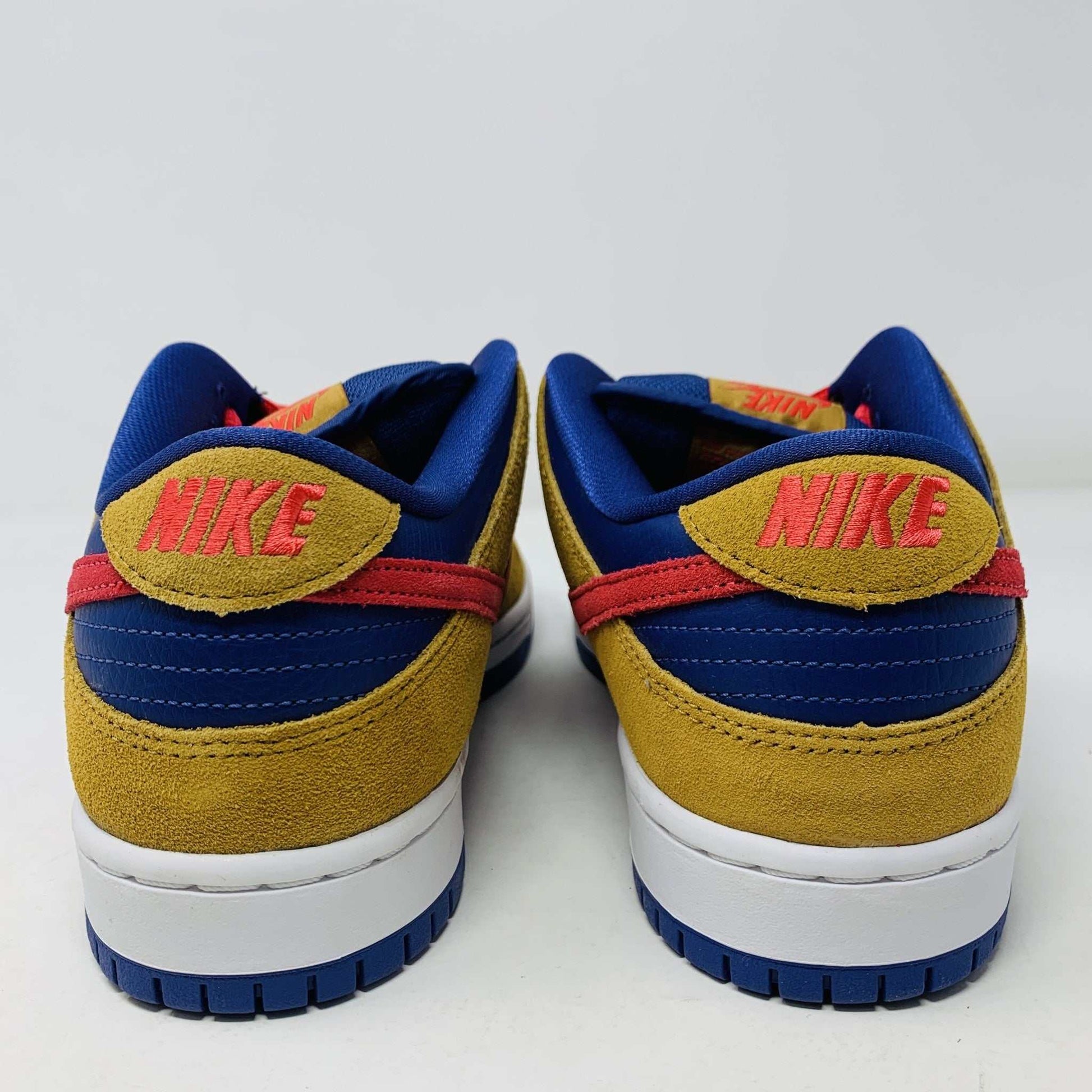 The Nike SB Dunk Low Reverse Papa Bear features a blue and yellow suede upper, a red Swoosh, and orange laces. It comes with extra yellow laces in front of its purple Nike SB box and is 100% authentic.