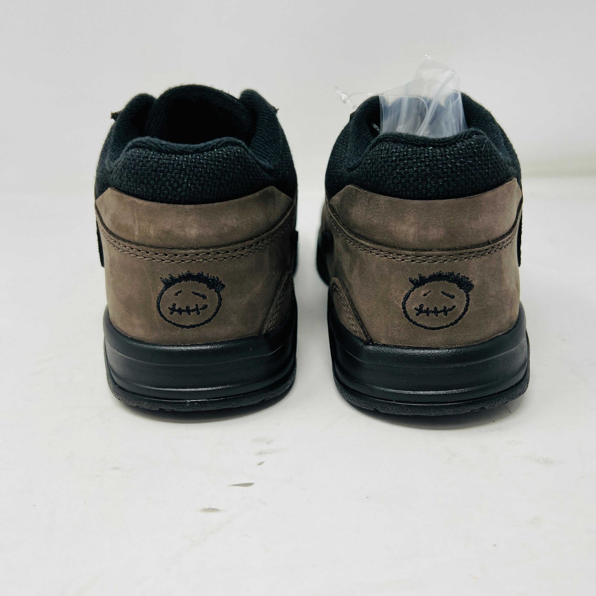 Rear view of Jordan Jumpman Jack TR Travis Scott Dark Mocha (PS) shoes with black stitching and heel design featuring a stitched face with messy hair and mouth, set against a neutral background.