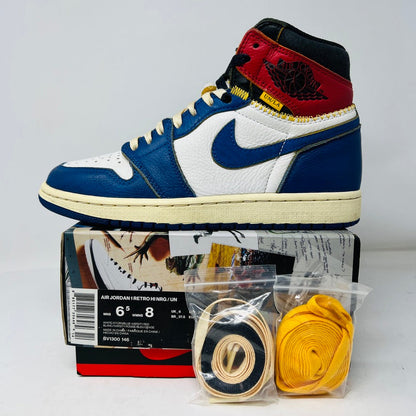 A close-up of a single Jordan 1 Retro High Union Los Angeles Storm Blue sneaker in white, blue, red, and black with clean uppers and yellow stitching. Its displayed on a Star Lost box with extra yellow and black laces packaged in front.