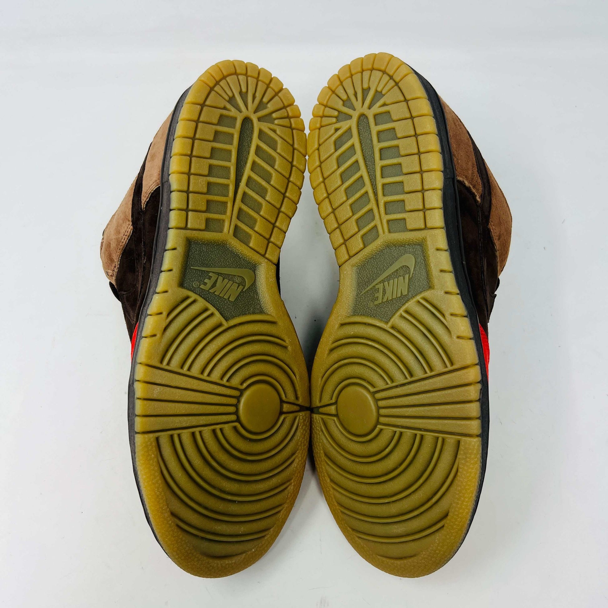 A pair of BRAND NEW Nike SB Dunk Low Bison sneakers featuring brown and red suede uppers, black laces, EXTRA LACES included, and a light brown sole. Positioned side by side on a white background, they promise to be 100% authentic and stylish.