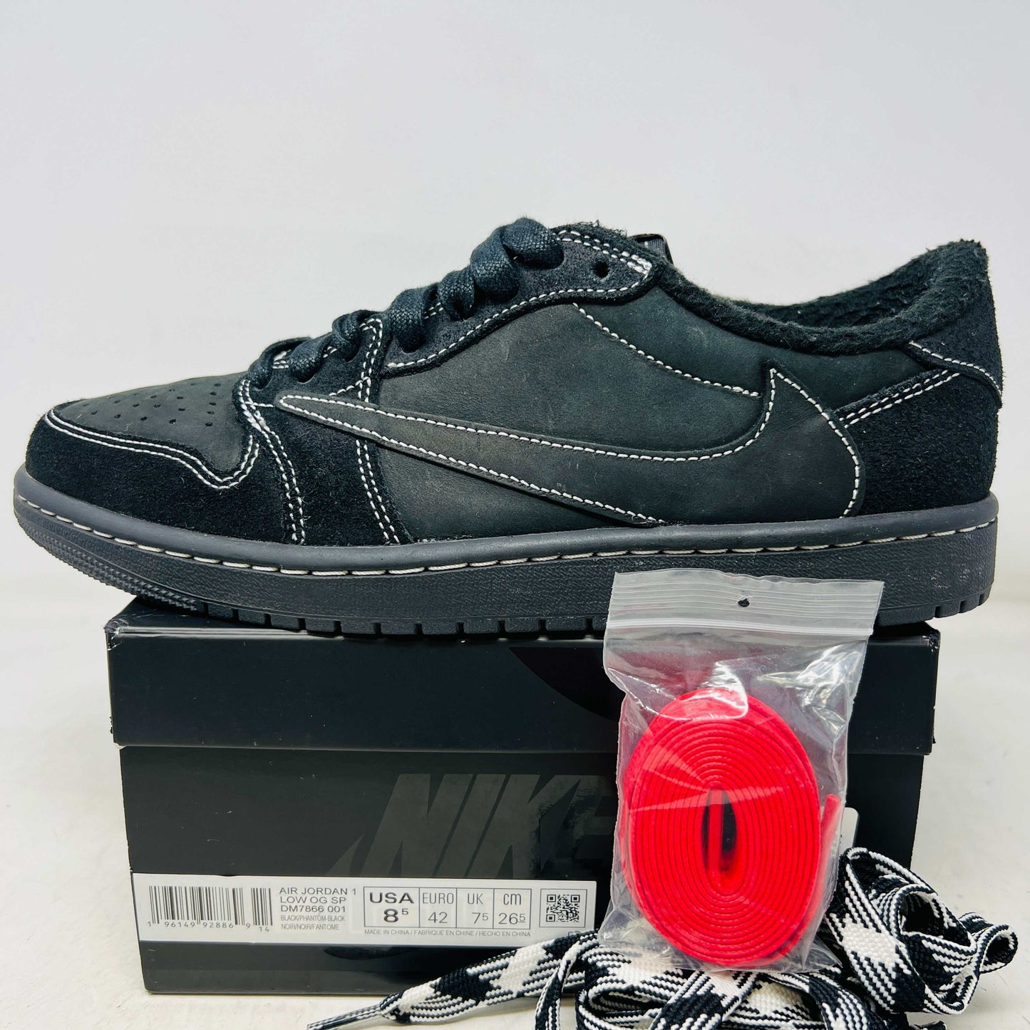 Jordan 1 Retro Low OG Travis Scott Black Phantom sneaker with red laces on Nike box