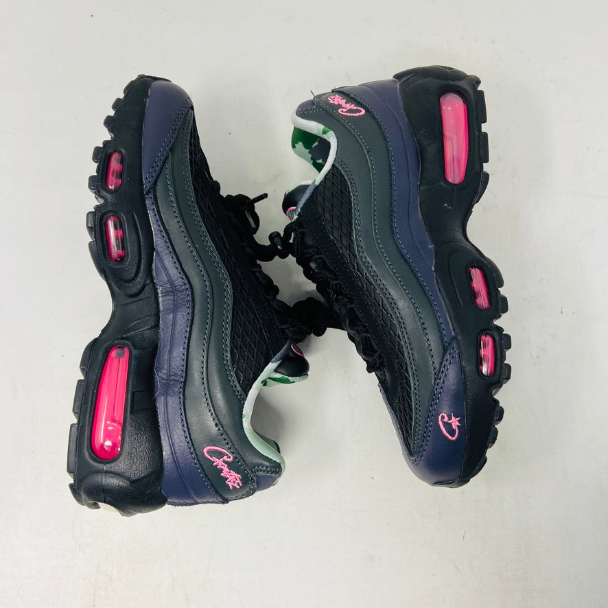 Introducing the Nike Air Max 95 SP Corteiz Pink Beam, black sneakers with textured design and purple accents. They feature a pink logo on the tongue, green and gray camo inner lining, black laces with toggle fasteners, fitting perfectly into 2021 fashion trends; available without a box.