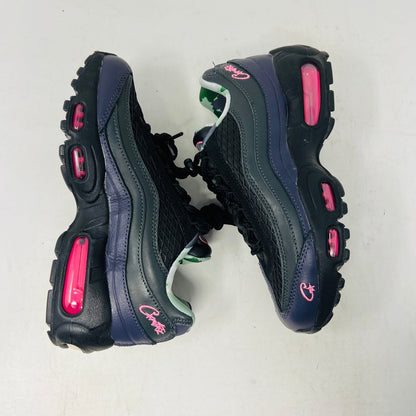 Introducing the Nike Air Max 95 SP Corteiz Pink Beam, black sneakers with textured design and purple accents. They feature a pink logo on the tongue, green and gray camo inner lining, black laces with toggle fasteners, fitting perfectly into 2021 fashion trends; available without a box.