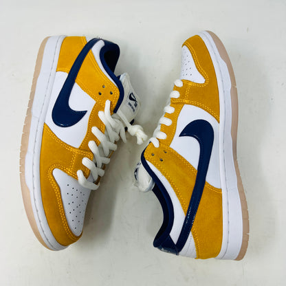 A new Nike SB Dunk Low Laser Orange 8 sneaker, featuring yellow and white suede and leather with a blue swoosh, is displayed on a purple Nike SB box. It includes a white sole, white laces, and extra laces.