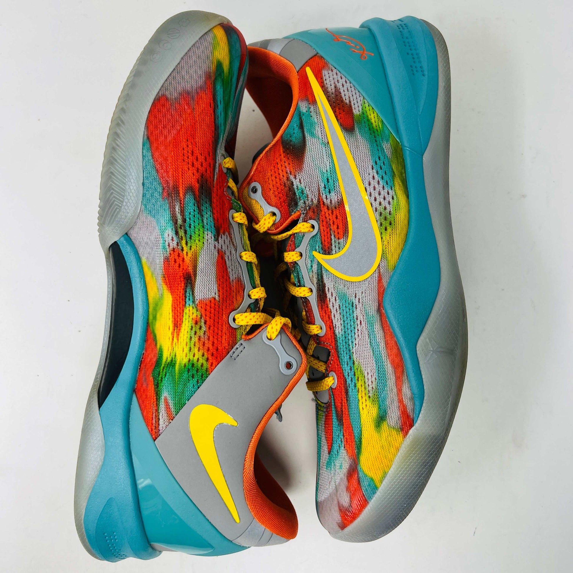 The Nike Kobe 8 Protro Venice Beach (2024) sneakers, featuring vibrant red, blue, yellow, and green brushstroke patterns with clean uppers and yellow laces paired with an orange lining, boast excellent condition at 8.5/10. A distinct logo adorns the gray tongue as they lay side by side on a white background.