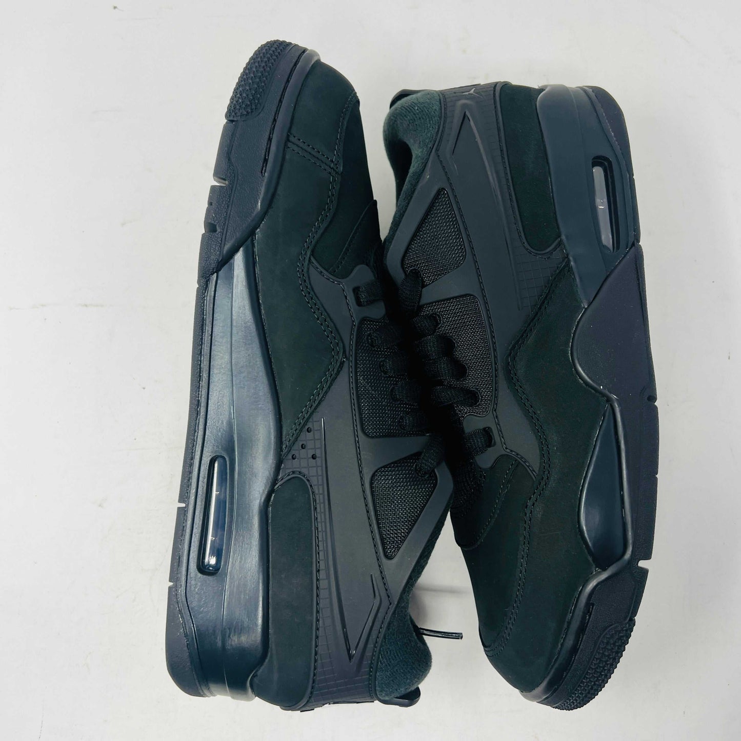 Jordan 4 RM Black Cat sneaker with black and grey design, leather upper, and Air-Sole heel unit.