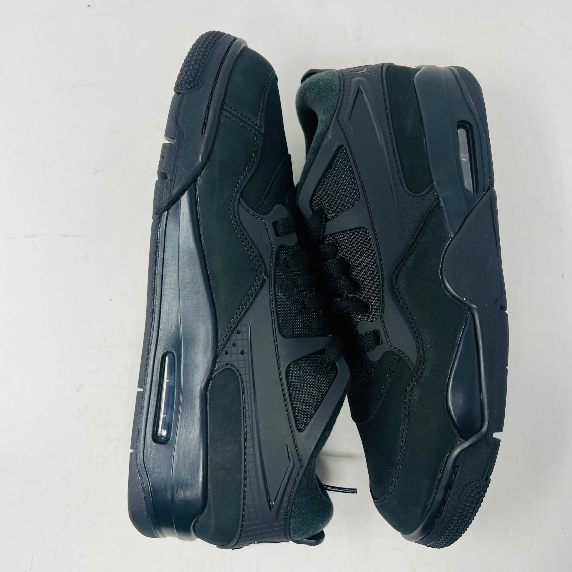 Jordan 4 RM Black Cat sneaker with black and grey design, leather upper, and Air-Sole heel unit.