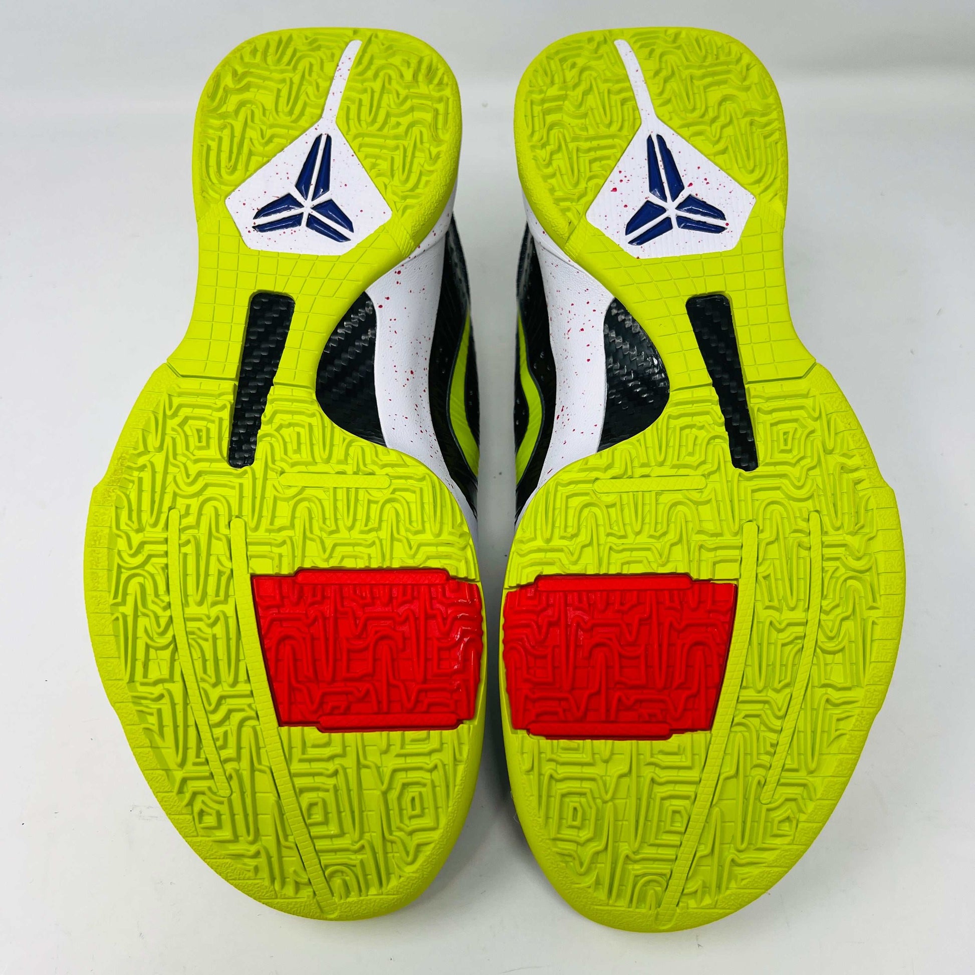 The Nike Kobe 5 Protro Chaos sneaker, authentic and vibrant, is showcased on a black shoe box. It features a bright lime green Nike swoosh, purple and white accents, a speckled pink midsole, red-speckled laces, and a textured gray heel.