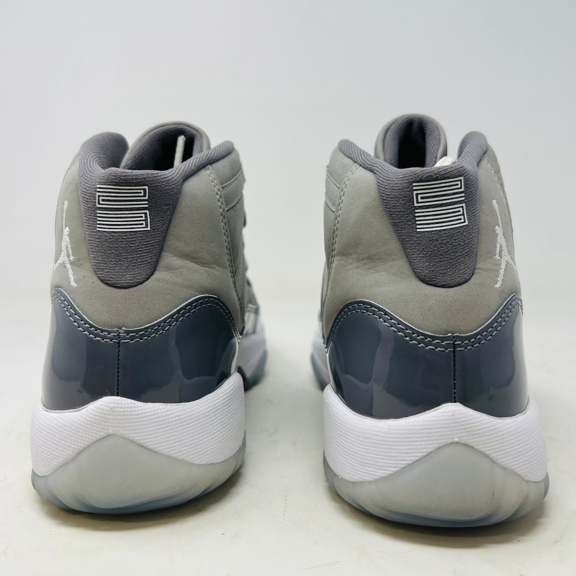 A Jordan 11 Retro Cool Grey (2021) (GS) sneaker by Jordan, in gray and white with a glossy patent leather finish, is displayed on its original Nike shoebox. The box is in good condition featuring a size 6.5Y label and various details, with clean uppers showing light wear and an orange sticker numbered 71.