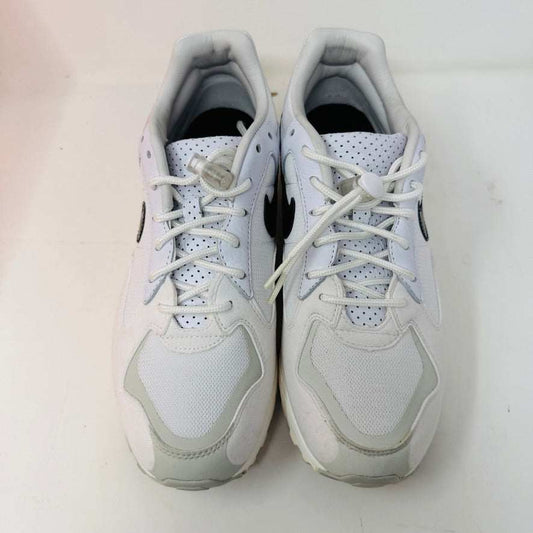 A pristine Nike Air Skylon 2 Fear of God sneaker with a black swoosh rests on its orange and white box. The label shows the model and size, while the sneaker boasts sleek uppers and retro design with a white sole.
