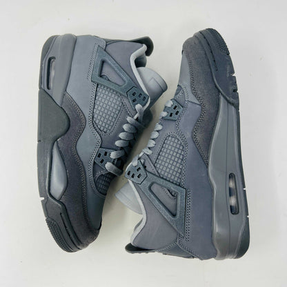 The Jordan 4 Retro SE Paris Olympics Wet Cement (GS), a brand-new gray sneaker, sits atop its pristine box. Featuring mesh and suede elements, it has a visible air unit in the midsole and a rubber outsole, poised to make an impression in 2024 against a plain white background.