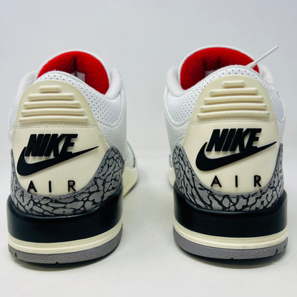 The Jordan 3 Retro White Cement Reimagined features white uppers with gray elephant print and red details, displayed on a black Nike Air shoebox. The size on the box reads 11, and the sneakers are pristine, free from heel drag.