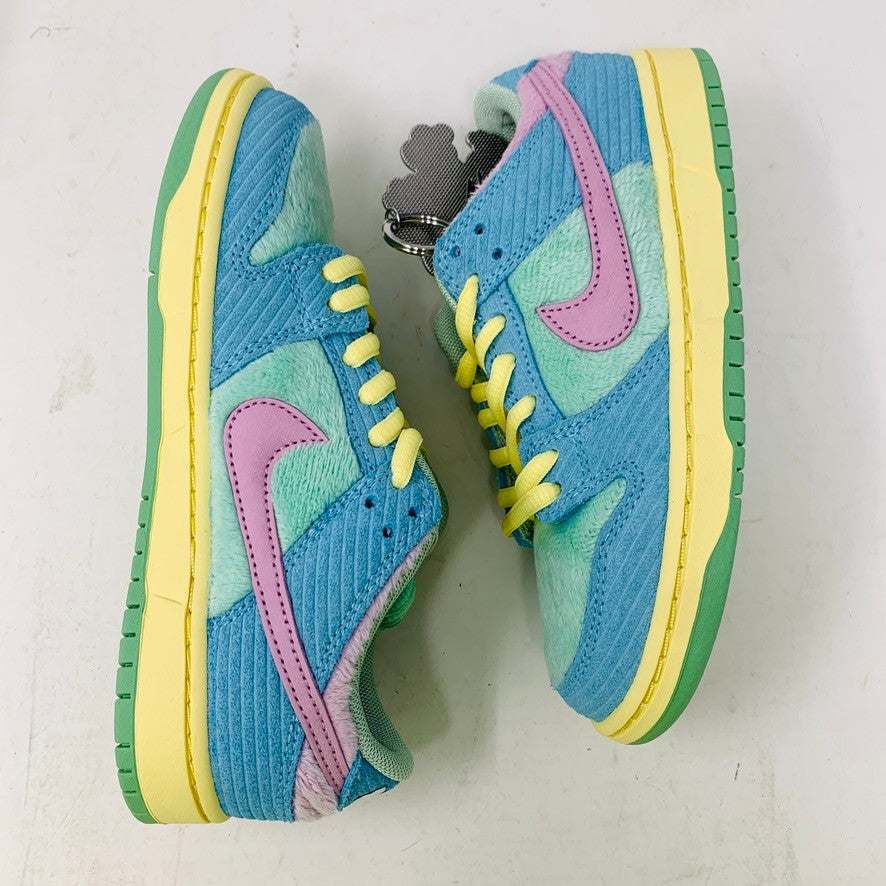The 100% authentic Nike SB Dunk Low Verdy Visty (PS) sneaker showcases blue, pastel yellow, pink, and mint green accents with textured fabric and a pink swoosh. It is displayed atop a white Nike SB shoebox.