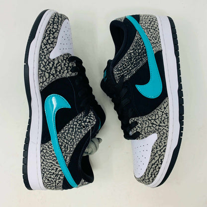 The Nike SB Dunk Low atmos Elephant sneakers feature a black and white textured pattern, teal Nike swoosh, and black laces, displayed on a purple Nike SB box with a white swoosh logo, ensuring 100% authenticity.