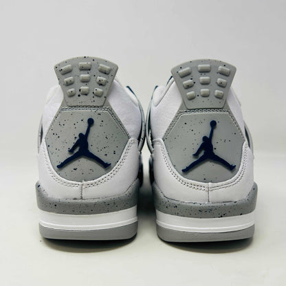 A brand new Jordan 4 Retro Midnight Navy (GS) sneaker from 2022 sits atop a red Nike shoe box with the iconic swoosh, featuring a white and gray design, leather and mesh mix, dark blue accents, and a visible air unit in the sole.