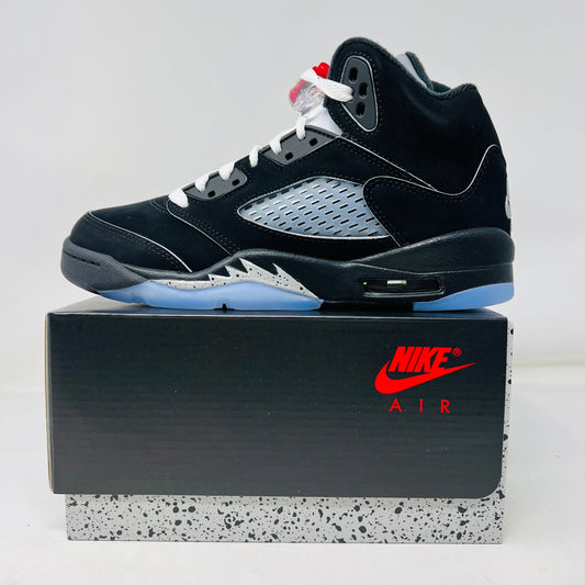 Brand new black and silver Jordan 5 Retro OG Black Metallic Reimagined (GS) sneakers from Jordan, featuring red accents, mesh side panels, black laces, a visible air unit in the heel, and a blue-tinted translucent outsole. The shoes come showcased on a black speckled shoebox.