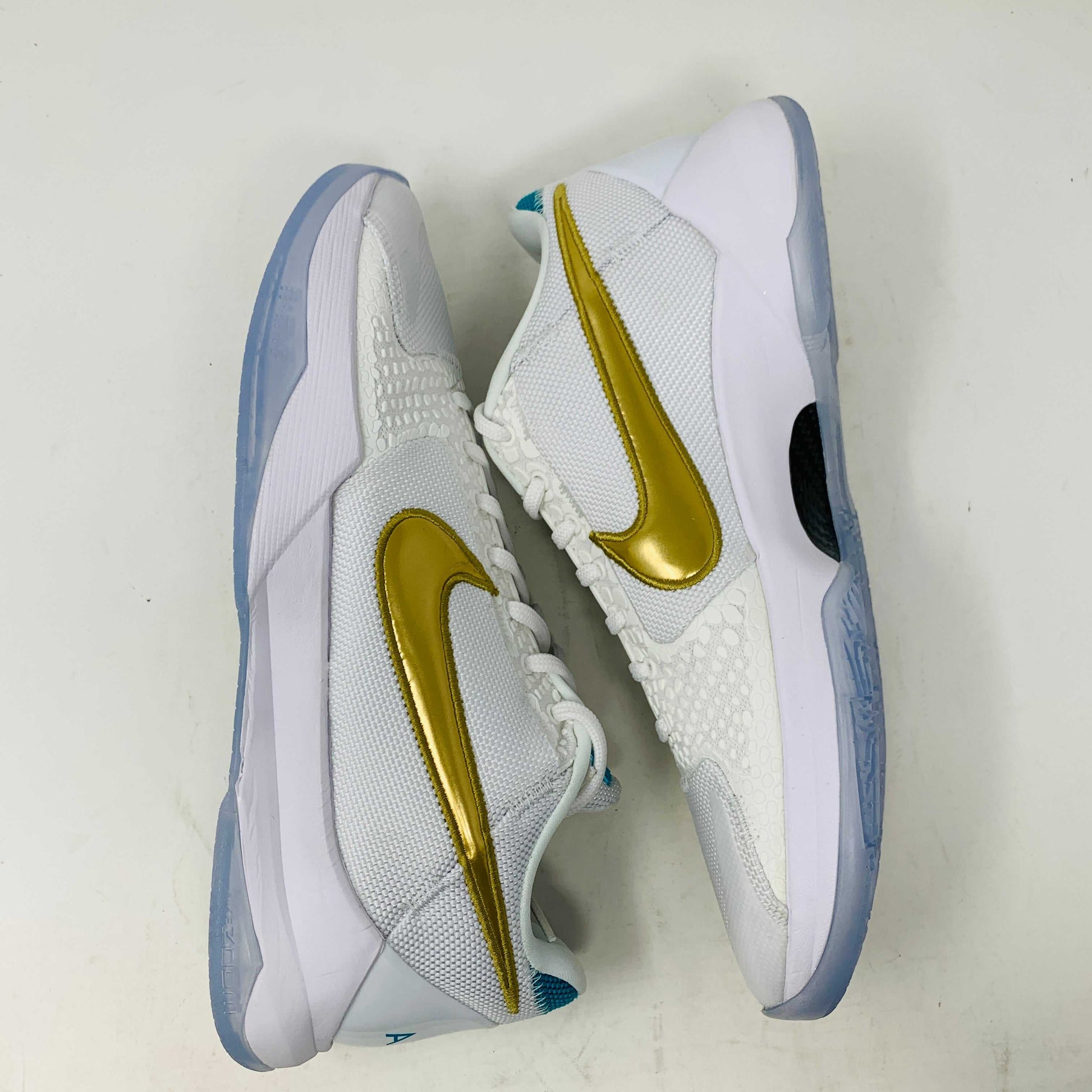 Kobe V Protro Undefeated Pack sneakers in white with gold accents and Protro technology.