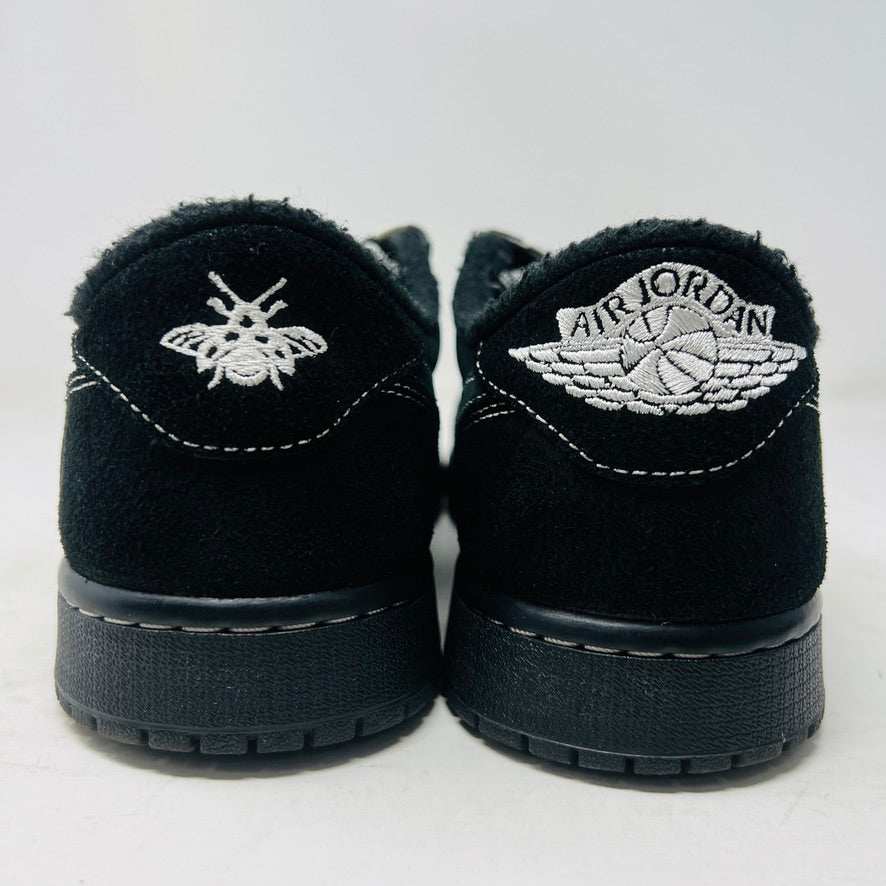 A pair of Jordan 1 Retro Low OG SP Travis Scott Black Phantom sneakers with perforated toe boxes and black and white checkered laces includes extra laces for added style. These authentic Jordans are displayed side by side on a white surface.