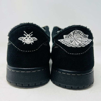 A pair of Jordan 1 Retro Low OG SP Travis Scott Black Phantom sneakers with perforated toe boxes and black and white checkered laces includes extra laces for added style. These authentic Jordans are displayed side by side on a white surface.