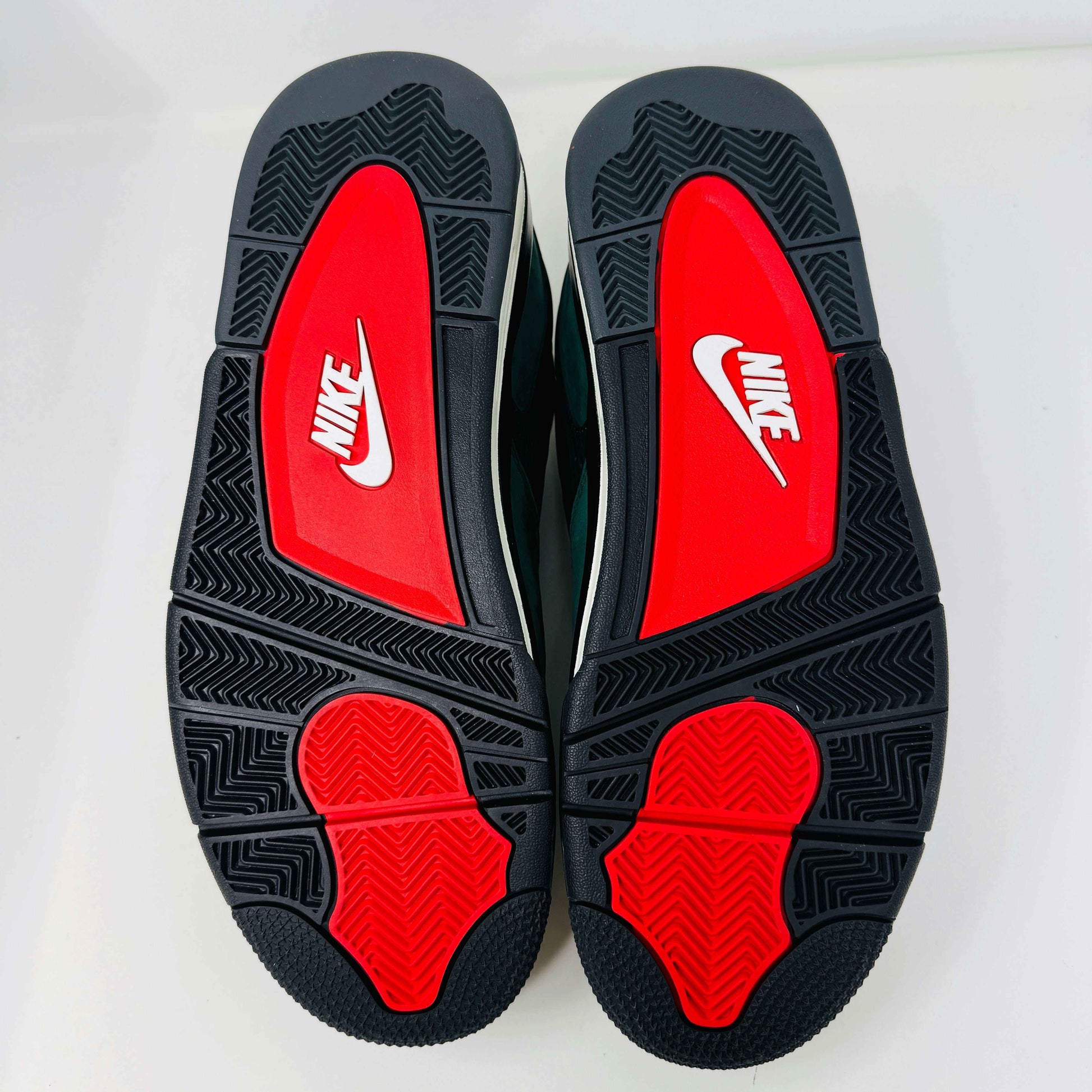 The Jordan 4 RM SP Nigel Sylvester Grandmas Driveway sneakers feature a dark green color with Air by Jordan on the tongue in white, accented with white laces and a low-top design, all set against a plain white background.