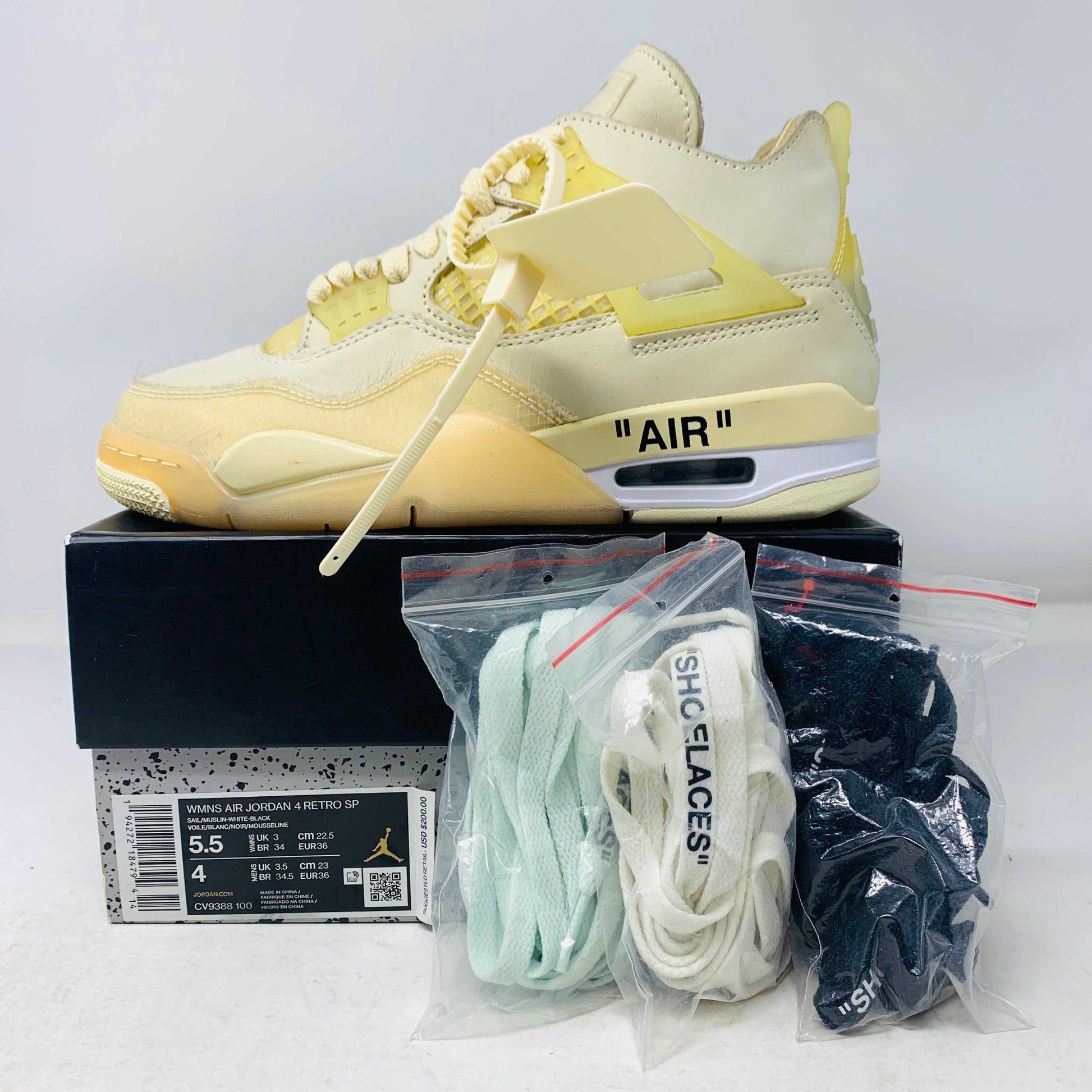 Jordan 4 Retro Off-White Sail Women's sneakers with cream, teal, and black laces, hangtag, and zip tie, shown in display.