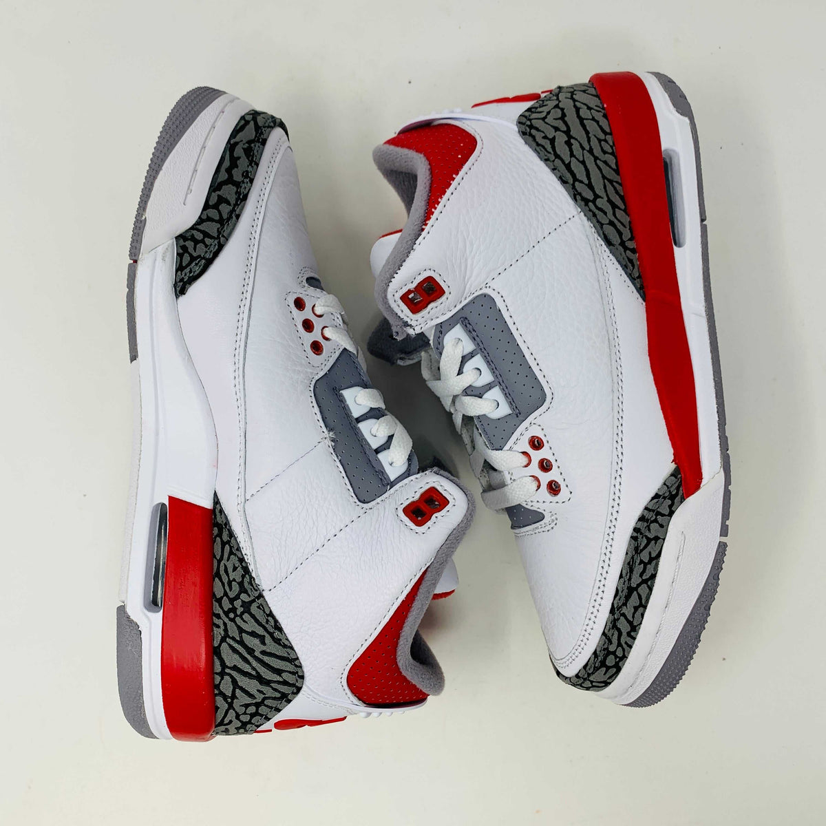 The Jordan 3 Retro Fire Red (2022) (GS) features white, red, and gray colors with elephant-print accents on a black-and-gray patterned box. The box has a red jumping silhouette and bold AIR lettering, making this BRAND NEW release ideal for collectors and enthusiasts.