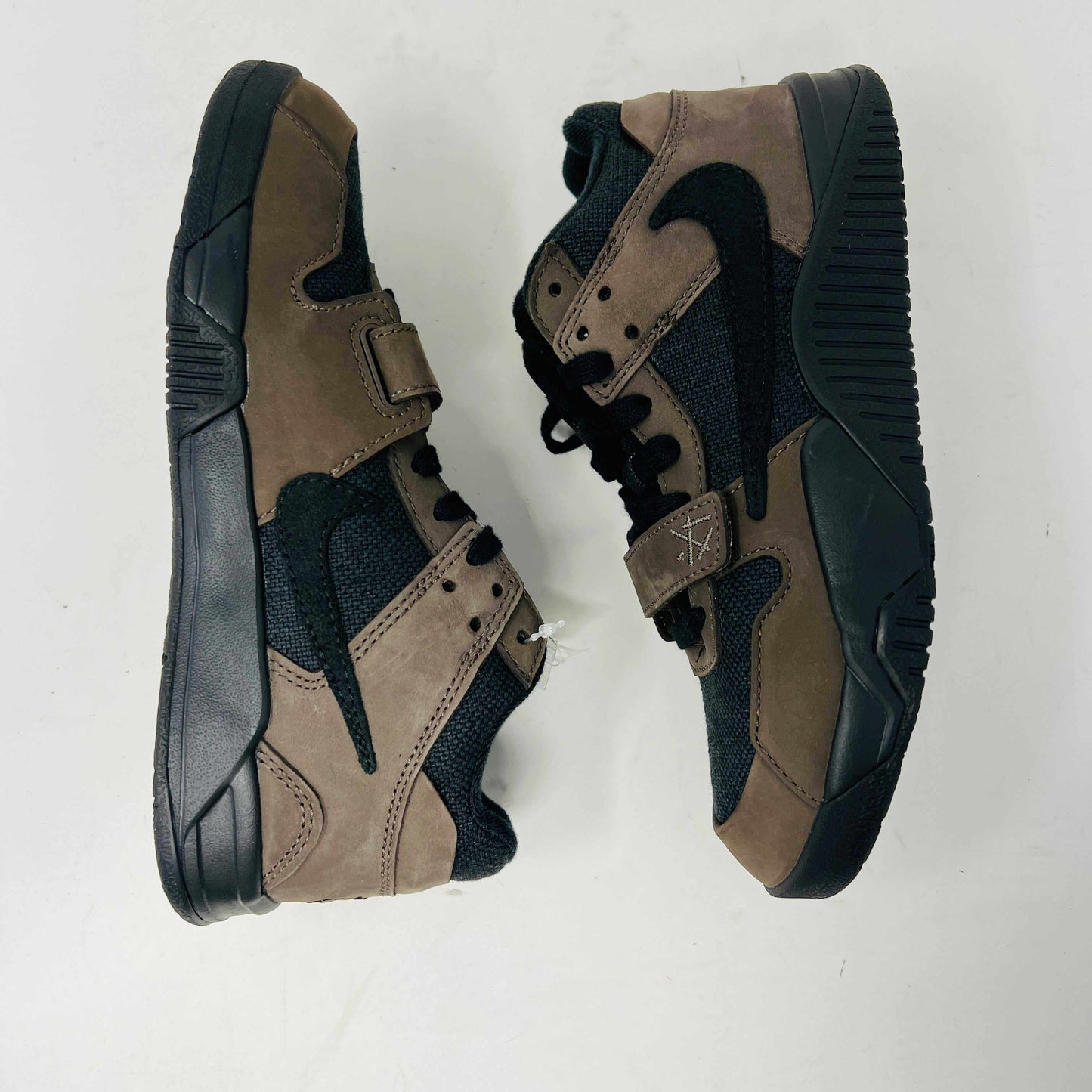 The Jordan Jumpman Jack TR Travis Scott Dark Mocha (PS) features brown and black high-top sneakers with suede material, black rubber soles, a forefoot strap, and a prominent black swoosh design. They are displayed side by side on a white background.